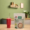 Doppelherz pure Bio Flohsamenschalen neben rotem Smoothie auf Tisch